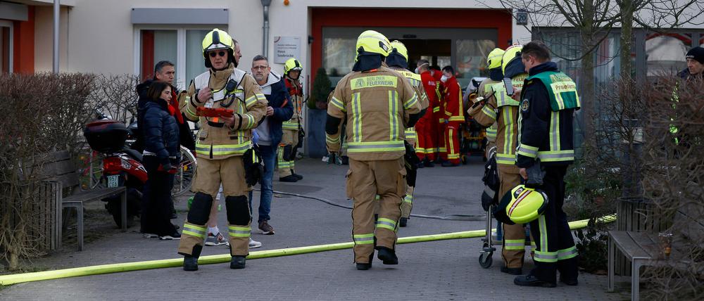 05.02.2023, Berlin: Einsatzkräfte der Feuerwehr stehen bei einem Einsatz vor dem Eingang des Pflegeheims Vivantes Hauptstadtpflege Haus Seebrücke in Hakenfelde. Bei einem Brand in der Pflegeeinrichtung ist eine Frau schwer verletzt worden. Foto: Carsten Koall/dpa +++ dpa-Bildfunk +++