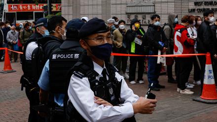 Polizisten stehen während der Anhörung der 47 pro-demokratischen Aktivisten, die der Verschwörung zum Umsturz nach dem Gesetz über die nationale Sicherheit angeklagt sind, vor dem Gebäude des West Kowloon Magistrates’ Courts in Hongkong.