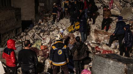 Syrische Zivilisten und Mitglieder der Weißhelme arbeiten an der Rettung von Menschen, die nach dem Erdbeben unter einem zerstörten Gebäude eingeschlossen sind. 