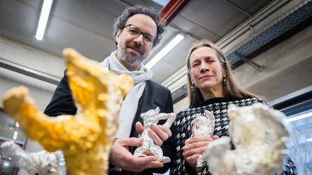 Das Leitungsduo der Berlinale, Carlo Chatrian, Künstlerischer Direktor, und Mariette Rissenbeek, Geschäftsführerin, halten in der Bildgießerei Hermann Noack Berlinale-Bären.