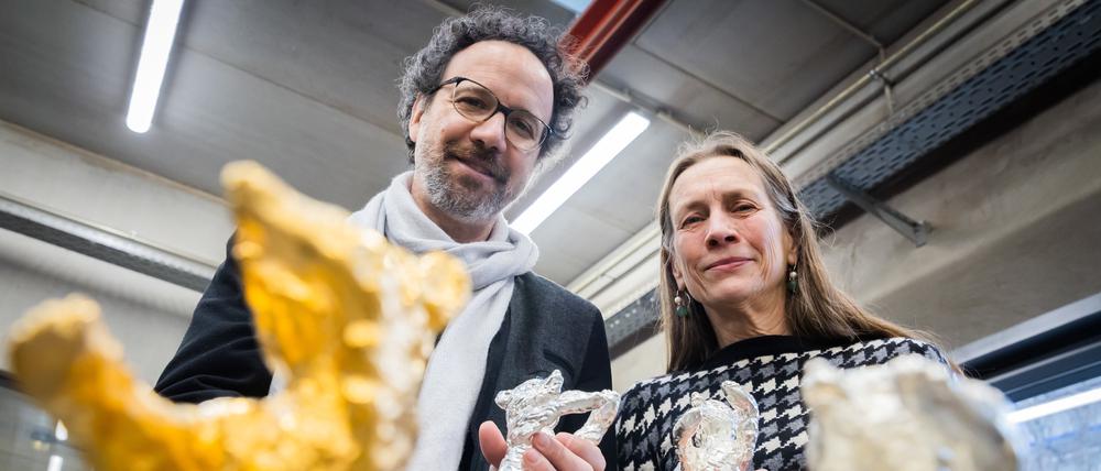 Das Leitungsduo der Berlinale, Carlo Chatrian, Künstlerischer Direktor, und Mariette Rissenbeek, Geschäftsführerin, halten in der Bildgießerei Hermann Noack Berlinale-Bären.