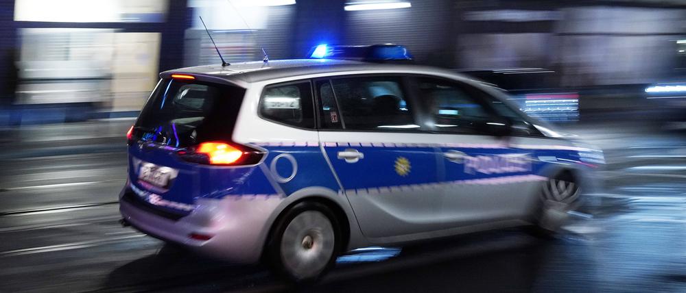 Ein Polizeiauto bei einer Einsatzfahrt mit Blaulicht.