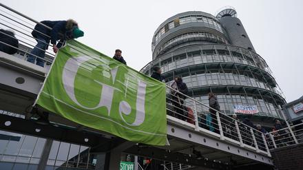 Mitarbeiterinnen und Mitarbeiter von RTL Deutschland hängen eine Flagge vor dem Verlagsgebäude am Baumwall gegen mögliche Verkäufe der Zeitschriften ab. 