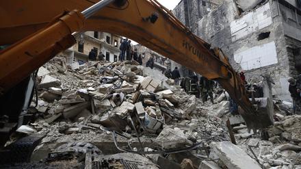 Mitarbeiter des syrischen Zivilschutzes und Sicherheitskräfte durchsuchen die Trümmer eingestürzter Gebäude in Aleppo.