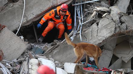 Ein Retter sucht nach dem Erdbeben in den Trümmern eines Gebäudes im türkischen Kahramanmaras nach Überlebenden.