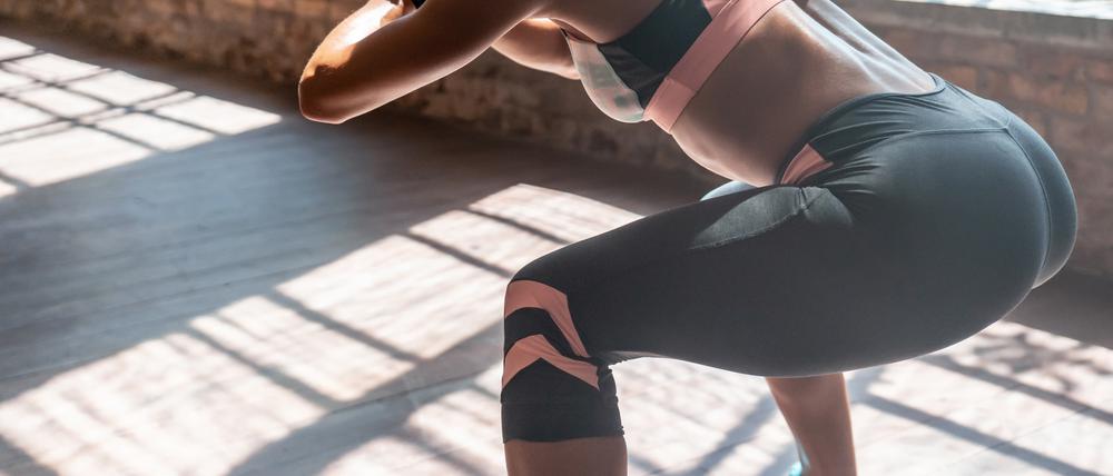 Squats, also tiefe Kniebeugen, sind eine beliebte Übung beim Training für den Po.