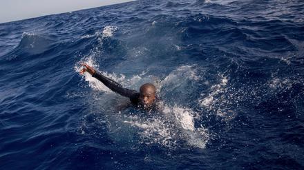 Ein Flüchtling versucht, im Mittelmeer auf das Boot einer deutschen Nichtregierungsorganisation zu gelangen. 