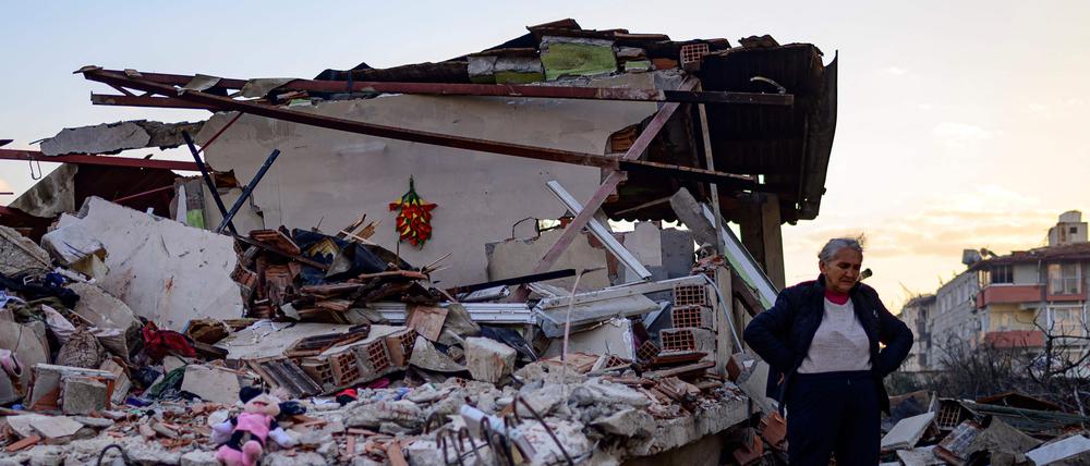 In der Provinz Hatay steht eine Frau in den Trümmern ihres Hauses.