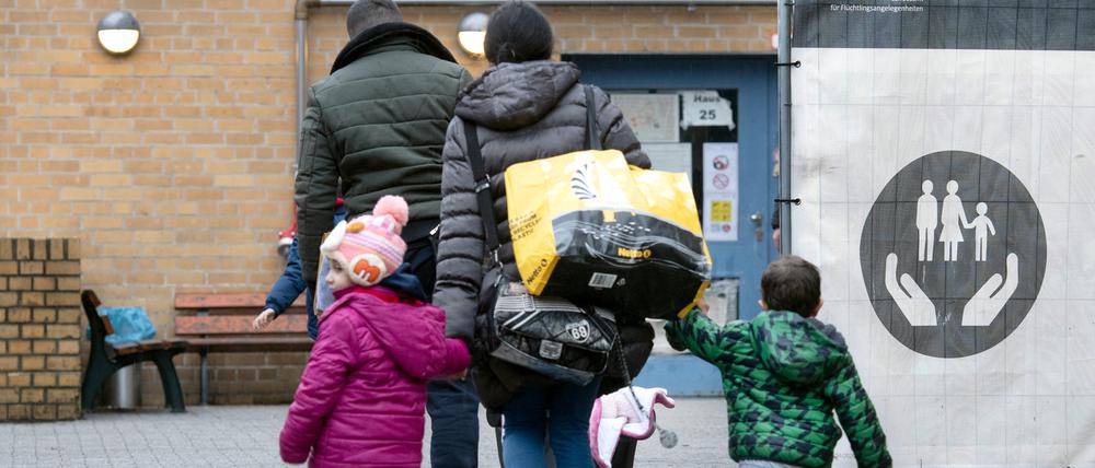 Ein Flüchtling geht mit seiner Familie auf dem Gelände der Erstaufnahmeeinrichtung des Landesamtes für Flüchtlingsangelegenheiten (LAF) in Reinickendorf.