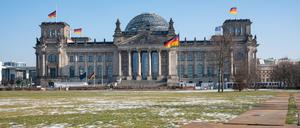 08.02.2023, Berlin, Deutschland, Europa - Schmelzender Schnee liegt auf dem Platz der Republik mit Blick auf den Reichstag im Berliner Bezirk Mitte. Die Fahnen auf dem Reichstagsgebaeude wehen auf halbmast aus Solidaritaet mit den Erdbebenopfern in der Tuerkei und Syrien. || Mindestpreis 25 Euro