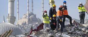Helfer suchen in den Trümmern eines Wohnblocks in Kahramanmaras (Türkei) nach Verschütteten. 