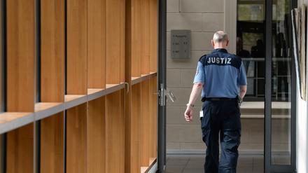 Kurz vor einer Urteilverkündung läuft am 10.04.2014 ein Justizwachtmeister durch einen Gang des Landgerichtes in Potsdam (Brandenburg). Für den Brandanschlag auf seine Ehefrau ist ein Mann aus Blankenfelde-Mahlow (Teltow-Fläming) am Donnerstag zu einer lebenslänglichen Freiheitsstrafe verurteilt worden. Das Potsdamer Landgericht befand den 51-Jährigen des versuchten Mordes, der gefährlichen und schweren Körperverletzung sowie schwerer Brandstiftung schuldig. Foto: Ralf Hirschberger/dpa ++ +++ dpa-Bildfunk +++