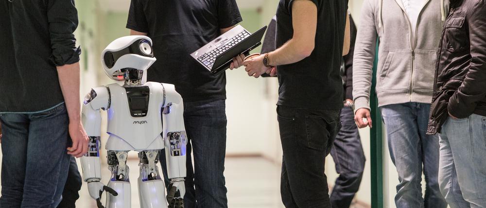 Symbolbild für den Forschungsbereich Robotik an der Berliner Hochschule für Technik (BHT). Im Bild Mitarbeitende und Studierende der BHT mit einem Myon-Roboter.