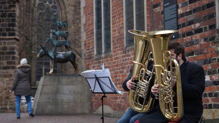 Vor dem Wahlprüfungsgericht verlor die AfD mit Pauken und Trompeten. Zwei Straßenmusiker mit Tuba sitzen neben der Bronzeplastik der Bremer Stadtmusikanten am Rande des Bremer Rathauses. (Symbolbild)