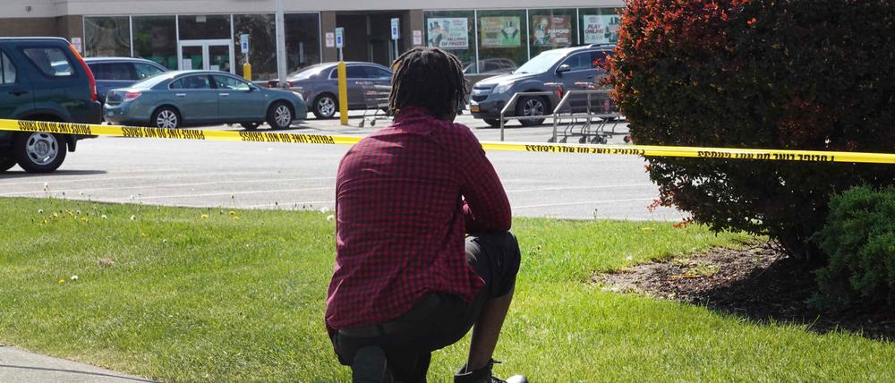 Eine Person kniet vor dem Tops-Markt in Buffalo, in dem ein Angreifer zehn Menschen erschossen hat (Archivbild).