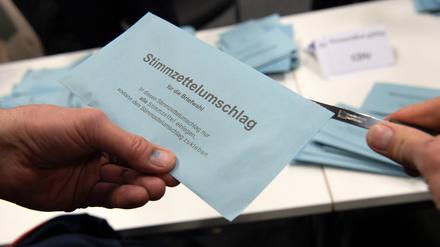 Stimmzettelumschlag eines Briefwählers wird im Briefwahllokal geöffnet.