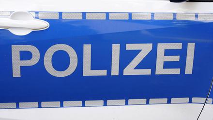 Schriftzug der Polizei an Poizeifahrzeug.