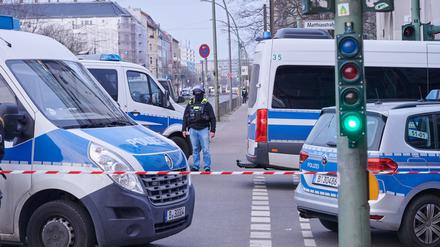Nach einem ausgelösten Amokalarm in einem Berliner Jobcenter stehen Einsatzfahrzeuge hinter der Absperrung an der Landsberger Allee. 