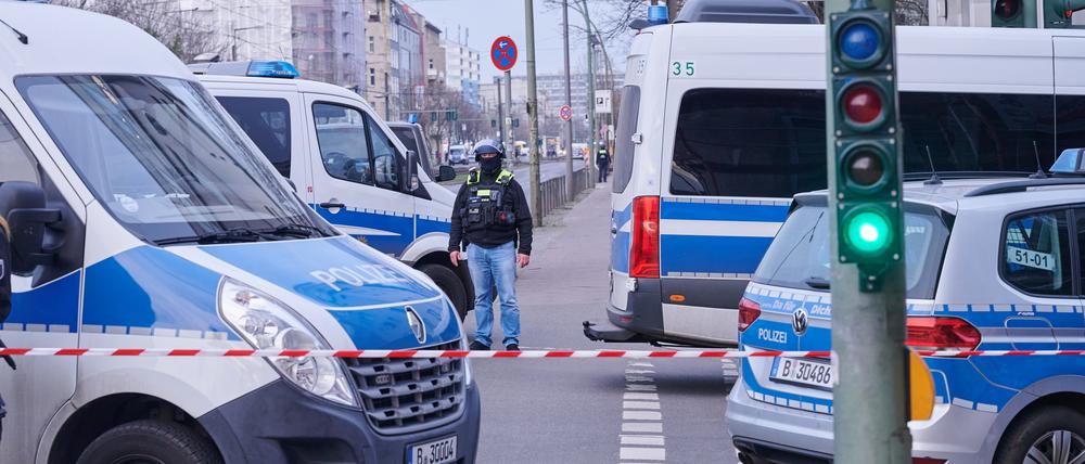Nach einem ausgelösten Amokalarm in einem Berliner Jobcenter stehen Einsatzfahrzeuge hinter der Absperrung an der Landsberger Allee.