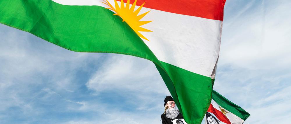 Aktivisten halten die iranische Flagge in die Höhe. 