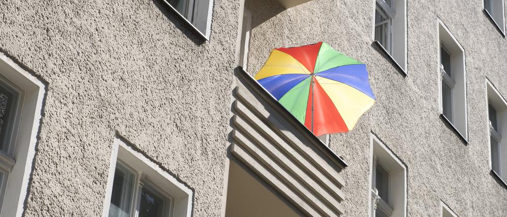 Bunter Sonnenschirm auf einem Balkon in der Greifenhagener Strasse in Berlin-Prenzlauer Berg.