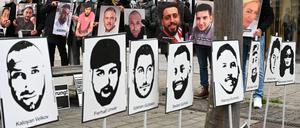Angehörige der Opfer des rassistischen Anschlags vom 19. Februar 2020 in Hanau halten bei einer Mahnwache vor dem hessischen Landtag Fotos der Opfer. 