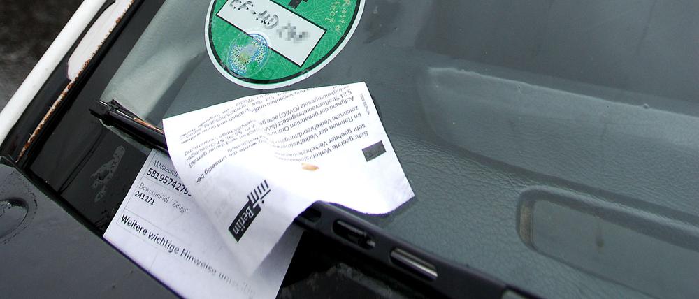 Strafzettel klemmen hinter dem Scheibenwischer an einer Windschutzscheibe. (Symbolbild)