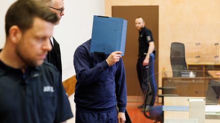 Johannes Salmen (2.v.l), Verteidiger des Angeklagten, steht neben seinem Mandanten in einem Saal im Landgericht.