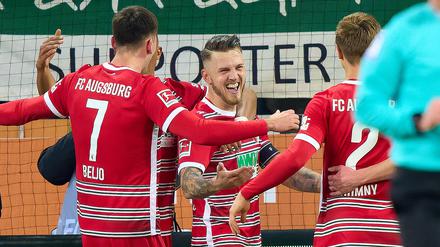 Fredrik Jensen (Mitte) mit dem goldenen Treffer für Augsburg in der 89. Minute.