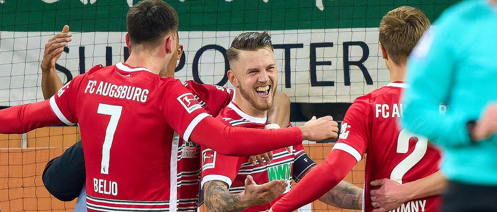 Fredrik Jensen (Mitte) mit dem goldenen Treffer für Augsburg in der 89. Minute.
