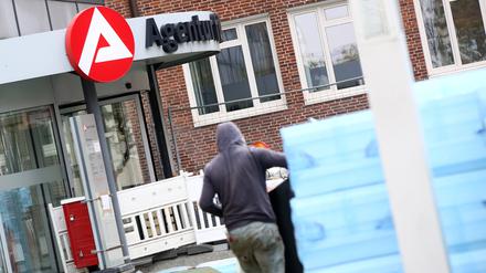 Vor der Agentur für Arbeit in Hamburg gehen Passanten an einer Baustelle vorbei.