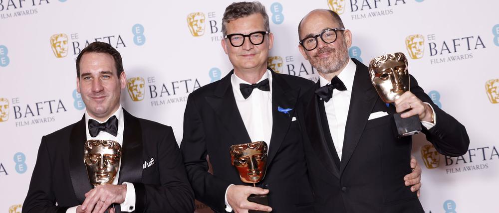 James Friend, Malte Grunert und Edward Berger posieren mit ihren Baftas.