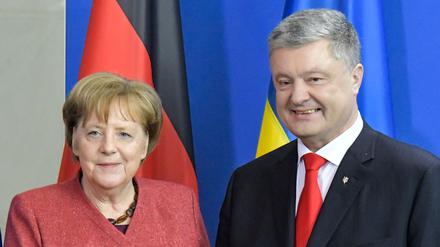 Bundeskanzlerin Angela Merkel und der ukrainische Präsident Petro Poroschenko geben sich nach einer gemeinsamen Pressekonferenz nach Gesprächen in Berlin die Hand (Archivbild).