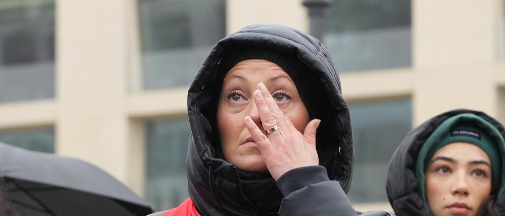 Eine Frau weint bei einer Gedenkveranstaltung zum Gedenken an die Opfer der Erdbeben in der Türkei und Syrien vor dem Brandenburger Tor in Berlin.