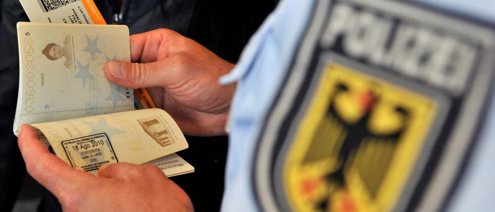 ARCHIV - Beamte der Bundespolizei führen am Flughafen Frankfurt/Main bei Reisenden, die gerade ihr Flugzeug über die Gangway verlasen haben, eine Dokumentensichtung durch (Foto vom 19.08.2010). Dank der EU fehlen Grenzkontrollen in Deutschland fast überall. Doch die Flughäfen bleiben Einfallstore für Schleuser und Geschleuste. Im Zuge einer Umstrukturierung der Sicherheitsbehörden sollen nach Meinung einer Expertenkommission Bundespolizei und Bundeskriminalamt (BKA) zusammengelegt werden. Foto: Marius Becker dpa/lhe +++(c) dpa - Bildfunk+++