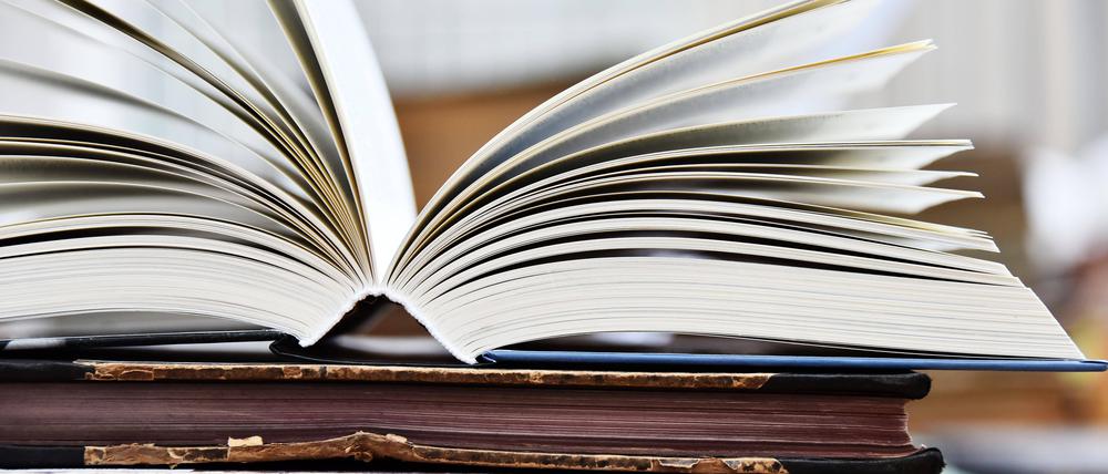 Aufgeschlagen, zugeschlagen. Buch in einer Bibliothek.