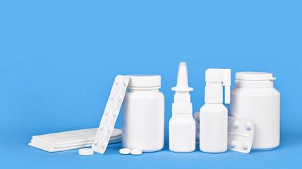 Medikamente gegen Erkältung und Grippe. Nasenspray, Rachenspray, Pillen und Taschentücher auf blauem Hintergrund mit Kopierraum || Mindestpreis 20 Euro 