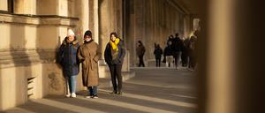 Three tourist ladies walk through a passage in Berlin during a cold winter day
