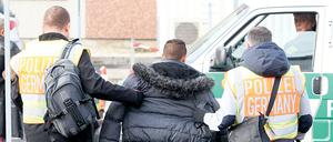 Polizisten begleiten einen straffällig gewordenen Asylbewerber 2015 zum Flughafen Leipzig-Halle.