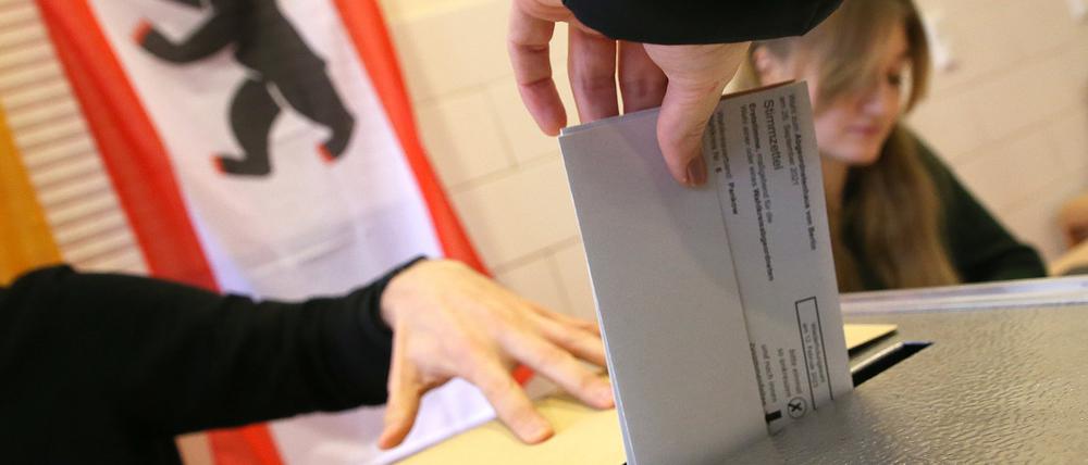 dpatopbilder - 12.02.2023, Berlin: Eine Frau gibt ihre Stimme für die Wahl zum Berliner Abgeordnetenhaus ab und wirft ihren Wahlzettel in die Wahlurne. Das Berliner Verfassungsgericht hatte entschieden, dass eine komplette Wiederholung der Wahl von 2021 wegen zahlreicher Pannen notwendig ist. Foto: Wolfgang Kumm/dpa +++ dpa-Bildfunk +++
