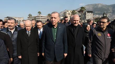 Der türkische Präsident Recep Tyyip Erdogan (Mitte) schaut sich das Ausmaß des Erdbebens in Hatay in der Türkei an.