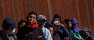 Migranten stehen an der Grenze zwischen Mexico und den USA.