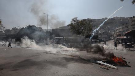 22.02.2023, Palästinensische Gebiete, Nablus: Israelische Streitkräfte feuern Tränengas auf palästinensische Demonstranten während den Zusammenstößen. Bei einem israelischen Militäreinsatz in Nablus im Westjordanland sind nach palästinensischen Angaben mindestens mehrere Palästinenser getötet worden. Foto: Ayman Nobani/dpa +++ dpa-Bildfunk +++