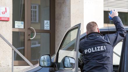 Ein Polizist vor seinem Auto.