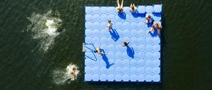 Schön, aber nicht ungefährlich: Menschen springen im Altwarmbüchener See von einer Badeinsel (Archivaufnahme).