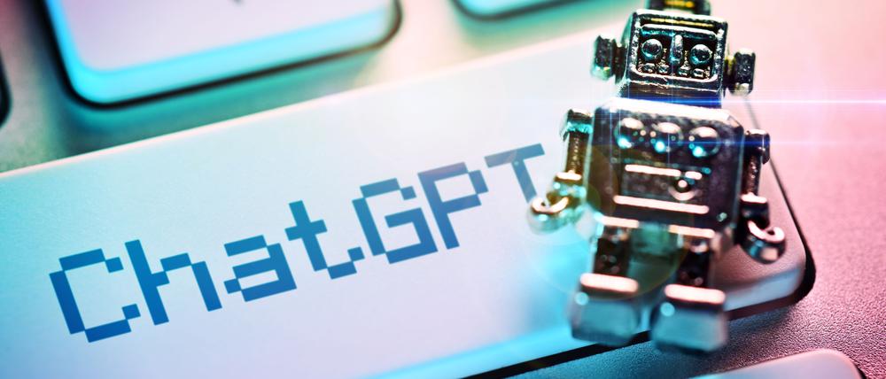 Miniatur-Roboter auf einer Computertaste mit der Aufschrift ChatGPT.