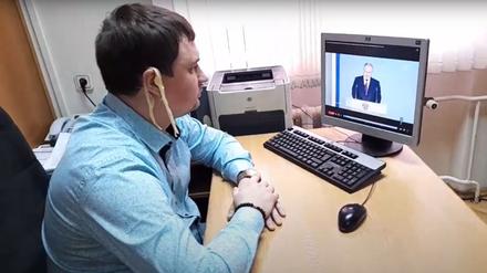 Der kommunistische Abgeordnete Michail Abdalkin schaut die Rede Putins an die Nation mit Spaghetti auf den Ohren.