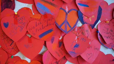 23.02.2023, Hamburg: Rote Herzen mit Friedenssymbolen und Wünschen der Schülerinnen und Schüler der Grundschule Molkenbuhrstraße hängen an einer Tafel im Schulgebäude. Am 24. Februar 2023 jährt sich der russische Angriffskrieg auf die Ukraine das erste Mal. Foto: Marcus Brandt/dpa +++ dpa-Bildfunk +++
