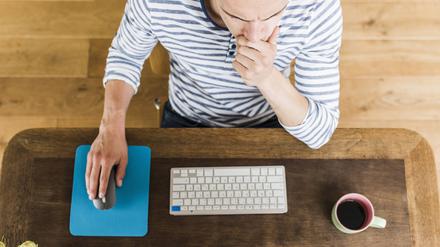 Man at wooden desk thinking || Modellfreigabe vorhanden