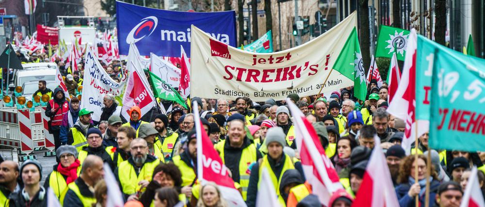 Streikende Demonstranten mit Transparenten ziehen am Vormittag durch die Frankfurter Innenstadt. 